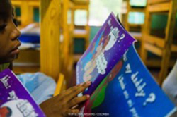 Young child reading book with blue page